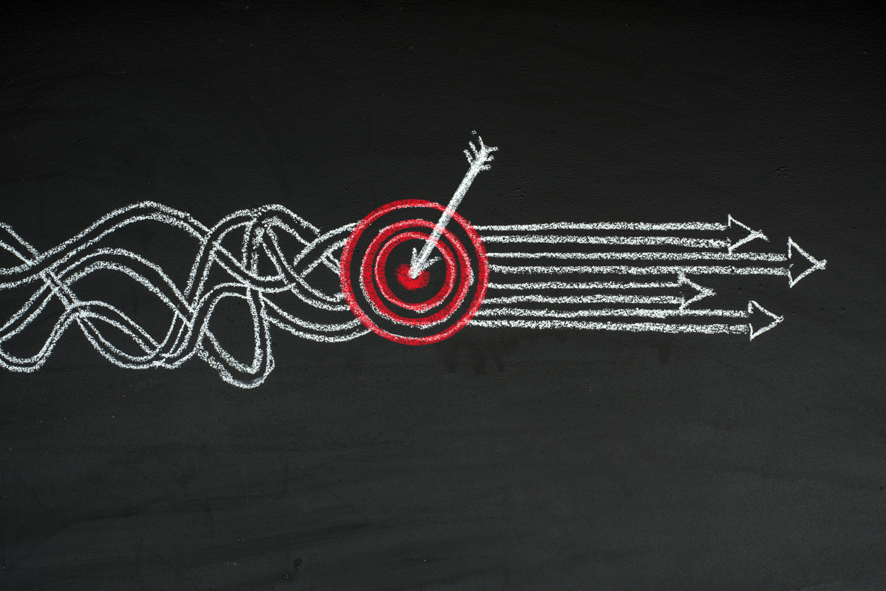 Chalkboard illustration of tangled lines straightening into arrows that hit a target